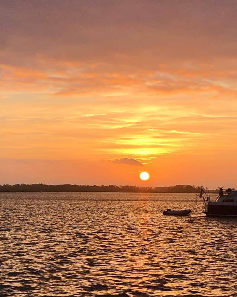 Sunset photo taken at the Pungo River anchorage. The entire sky is a bright orange! There is the back end and dinghy of a motor boat anchored next to us off to the right of the photo.