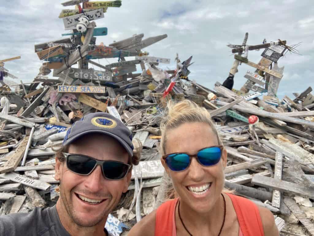 Scott and me on top of Boo-Boo Hill with a pile of driftwood and signs as offerings to King Neptune
