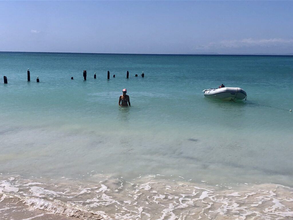 I'm in the water next to our dinghy anchored in the water at the beautiful beach