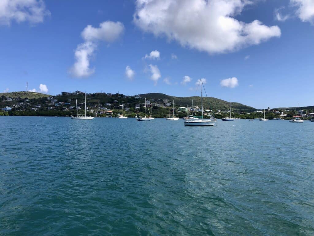 boats anchored in the anchorage with houses and mountains in the background in Culebra.