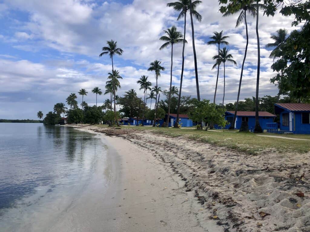 small beach lined with blue cottages near Puerto Real anchorage
