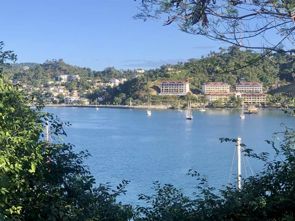 Pelagia in the anchorage at Samana, taken from the top of a hill on land behind the anchorage on a sunny day. The town of Samana is behind the anchorage.