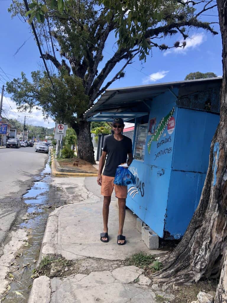 Scott at a bright blue food vendor on the streets of Samana.