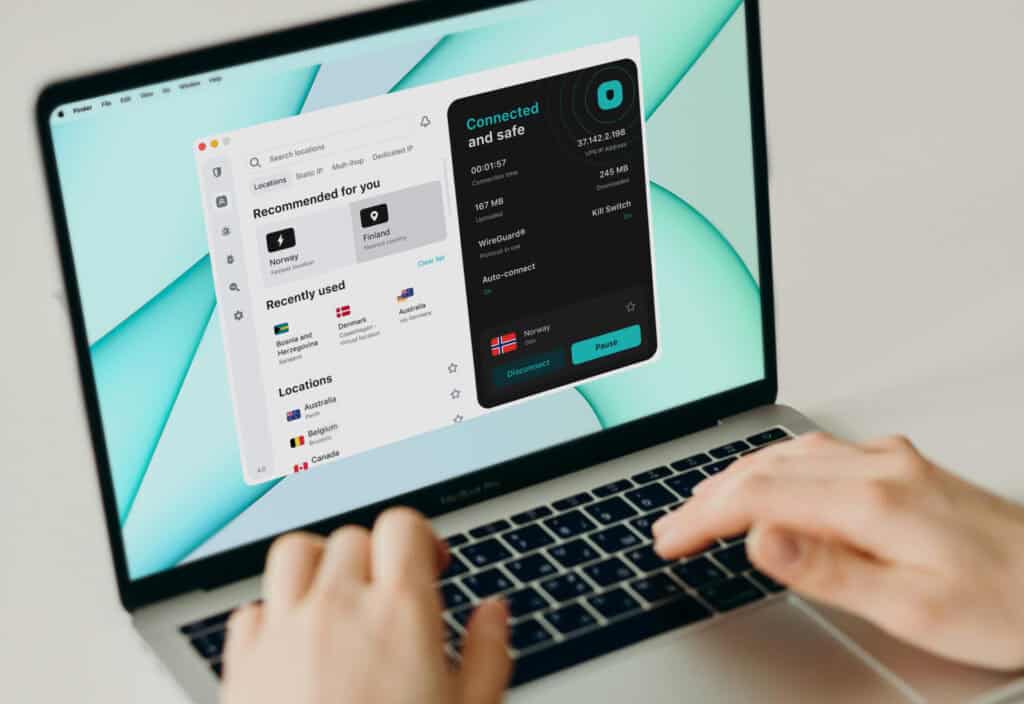 Person typing on a MacBook with the Surfshark VPN app open and connected to a server in Norway. The Surfshark Review screenshot shows the VPN connection status alongside server locations and security settings.